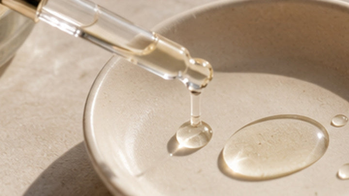 Gotas transparentes de aceite cosmético en un cuenco cerámico